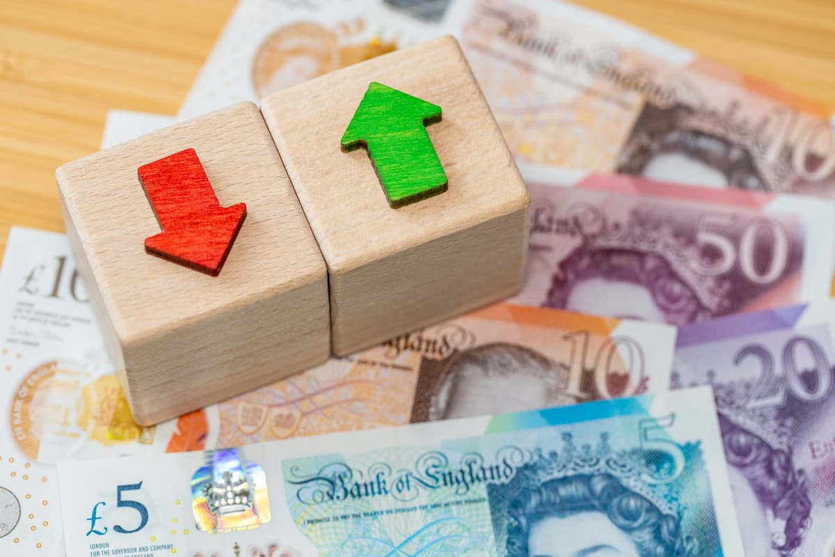 Bank of England interest rate decision concept with British pound sterling banknotes and wooden building blocks