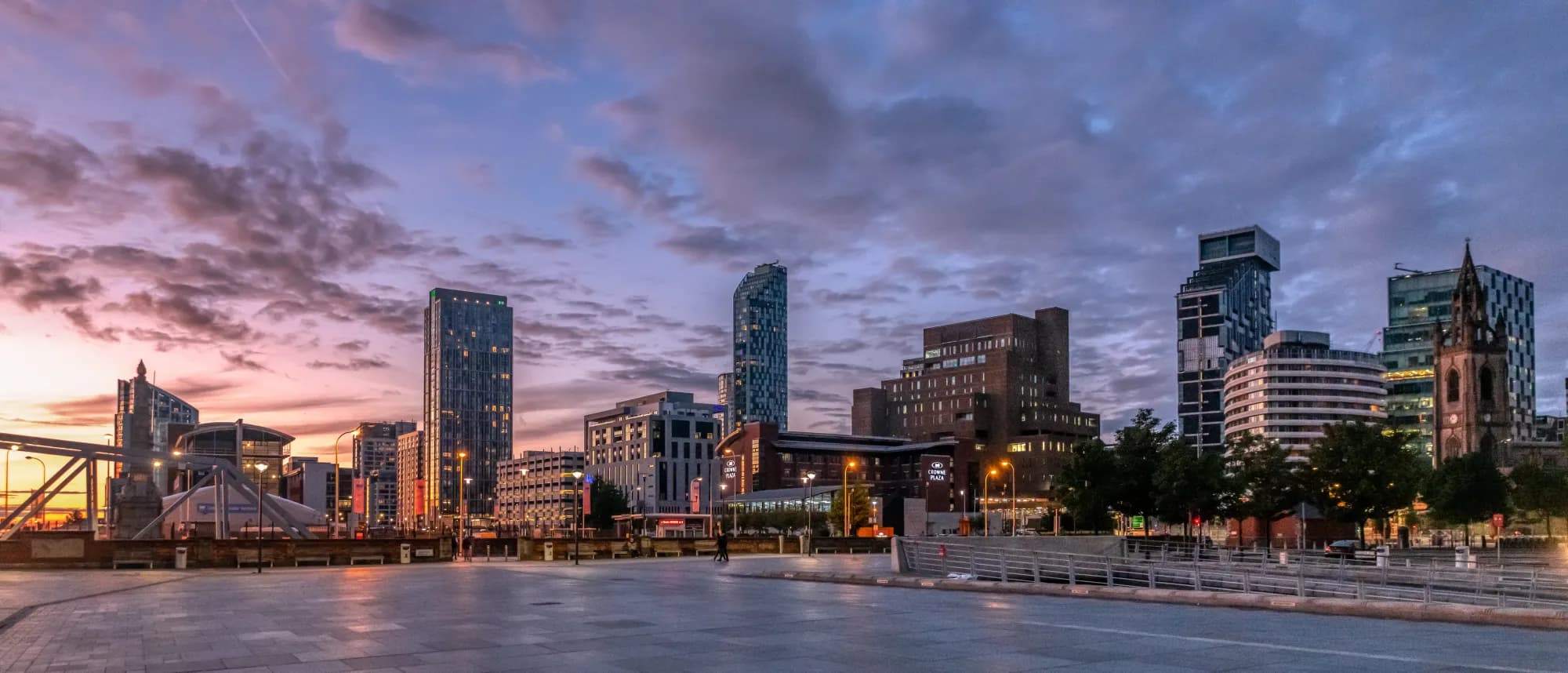 Liverpool skyline at sunset with modern waterfront buildings and iconic waterfront landmark
